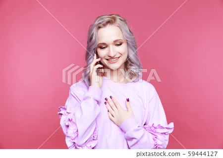 Glad cute young woman talking phone and smiling isolated. Glad cute young woman talking phone and smiling isolated. 59444127