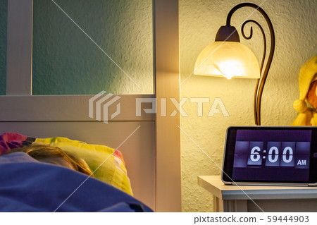 Little girl sleeping in bed - Alarm clock at 6 am in the morning. Little girl sleeping in bed - Alarm clock at 6 am in the morning. 59444903