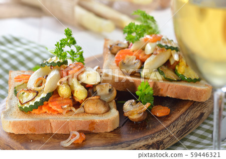 Veggie - Toast with fried white asparagus and other vegetables, served with a glass of white wine 59446321