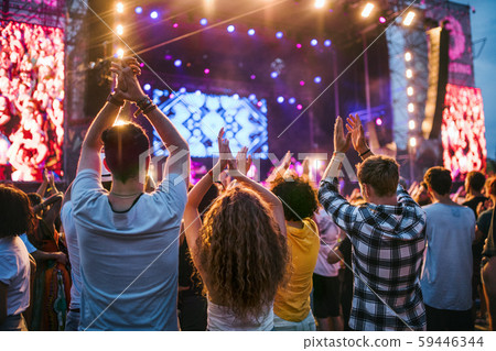 Rear view of group of young friends dancing at summer festival. 59446344