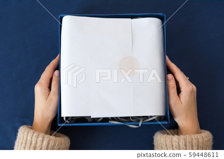 Unrecognizable woman holding gift in blue box. Happy winter holidays. Presents for Christmastime Unrecognizable woman holding gift in blue box. Happy winter holidays. Presents for Christmastime 59448611