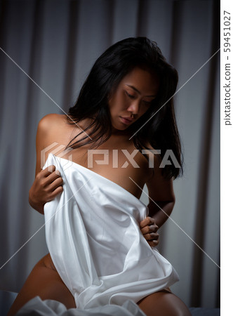 Naked sexy asian girl sitting on the bed 59451027