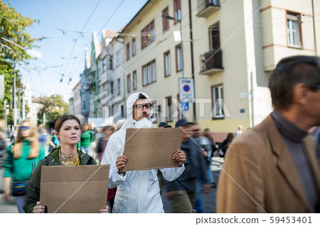 People with placards and protective suit on global strike for climate change. People with placards and protective suit on global strike for climate change. 59453401