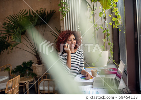 Businesswoman calling her colleague waiting for her in cafeteria Businesswoman calling her colleague waiting for her in cafeteria 59454118