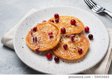 Cottage cheese pancakes with cranberries. Russian syrniki or sirniki, cottage cheese fritters or pancakes on the plate. Cottage cheese pancakes with cranberries. Russian syrniki or sirniki, cottage cheese fritters or pancakes on the plate. 59454883