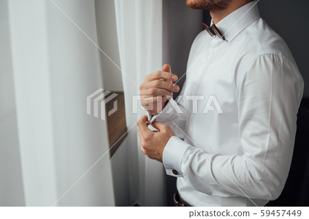 Man buttons cuff link on cuffs sleeves luxury white shirt. 59457449