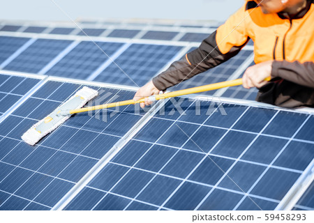 Workman cleaning solar panels 59458293