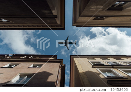 Passenger plane flying over the roofs of residential homes, low airplane flies, transportation 59458403