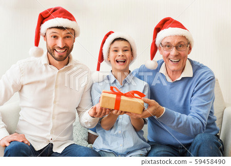 Boy, Father, Grandfather In Santa Hats Sitting On Couch Indoor 59458490