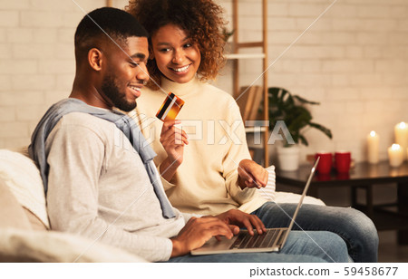 Happy spouses shopping online on laptop at home Happy spouses shopping online on laptop at home 59458677