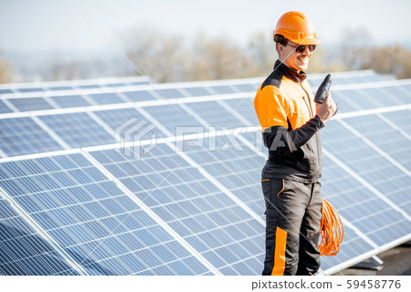 Well-equipped workman on a solar station 59458776