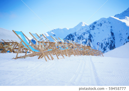 Sun loungers against backdrop of mountains at winter resort 59458777