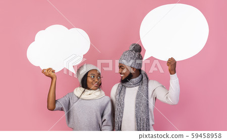 Young black winter couple holding communication bubbles at studio Young black winter couple holding communication bubbles at studio 59458958