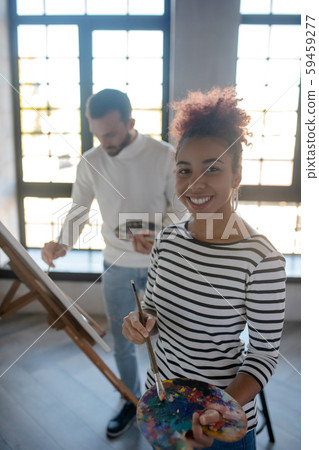 Cheerful young woman feeling inspired before painting Cheerful young woman feeling inspired before painting 59459277