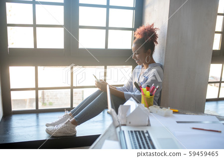 Interior designer having break while sitting near window 59459465