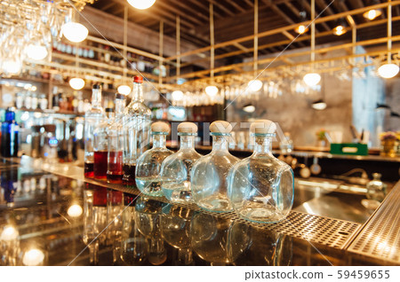 Clean washed and polished glasses hanging over a bar rack Clean washed and polished glasses hanging over a bar rack 59459655