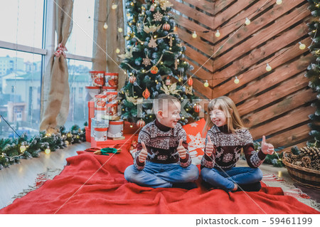 Caucasian siblings weared in claret wool sweaters are showing thumbs up, satisfied with new year Caucasian siblings weared in claret wool sweaters are showing thumbs up, satisfied with new year 59461199