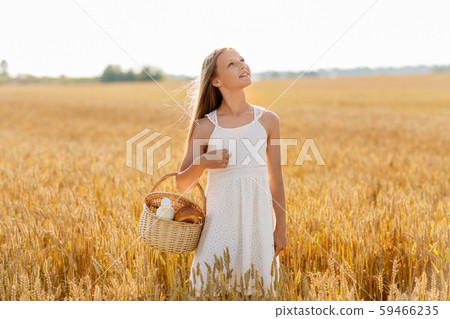 girl with bread and milk in basket on cereal field girl with bread and milk in basket on cereal field 59466235