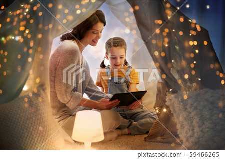 family with tablet pc in kids tent at home 59466265