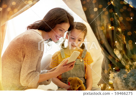 happy family with smartphone in kids tent at home happy family with smartphone in kids tent at home 59466275