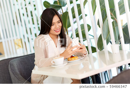 asian woman with smartphone at cafe or coffee shop 59466347