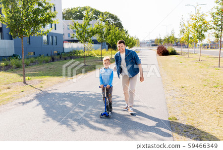 happy father and little son riding scooter in city happy father and little son riding scooter in city 59466349