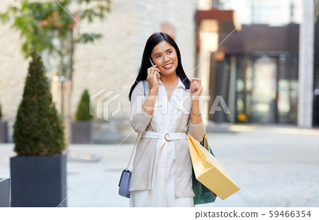 woman with shopping bags calling on smartphone woman with shopping bags calling on smartphone 59466354