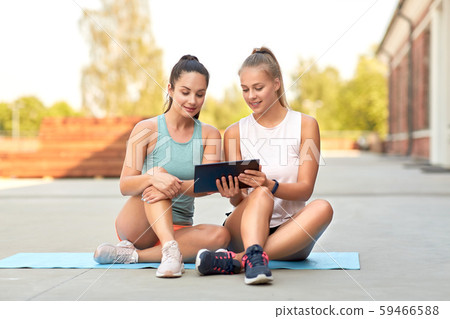sporty women or friends with tablet pc on rooftop 59466588