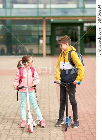 happy school children with backpacks and scooters happy school children with backpacks and scooters 59466634