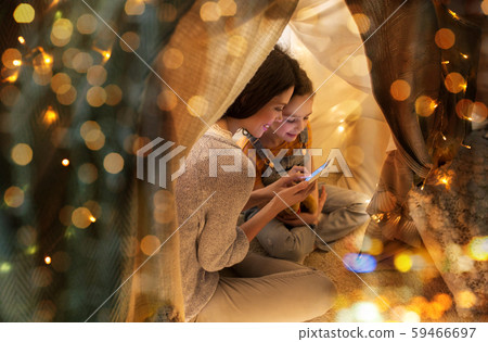 happy family with smartphone in kids tent at home happy family with smartphone in kids tent at home 59466697