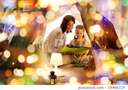 happy family reading book in kids tent at home 59466724