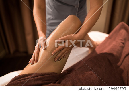 woman lying and having leg massage with gel at spa 59466795
