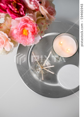 aroma reed diffuser, candle and flowers on table 59466948
