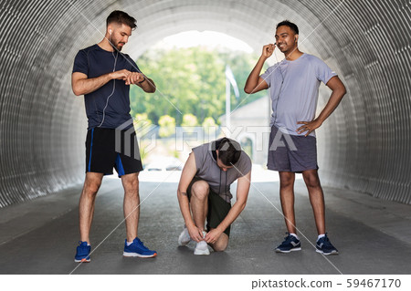 male friends with earphones training outdoors male friends with earphones training outdoors 59467170