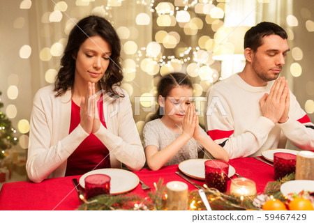 family praying before meal at christmas dinner family praying before meal at christmas dinner 59467429