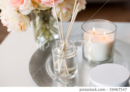 aroma reed diffuser, candle and flowers on table 59467547