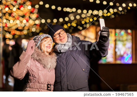 senior couple taking selfie at christmas market 59467565