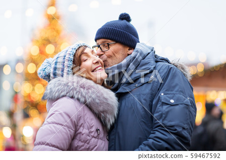 happy senior couple kissing at christmas market 59467592