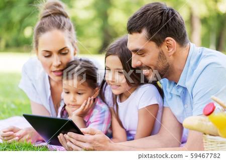 family with tablet pc on picnic in summer park family with tablet pc on picnic in summer park 59467782