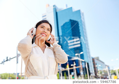 happy smiling asian woman with headphones in city happy smiling asian woman with headphones in city 59467786