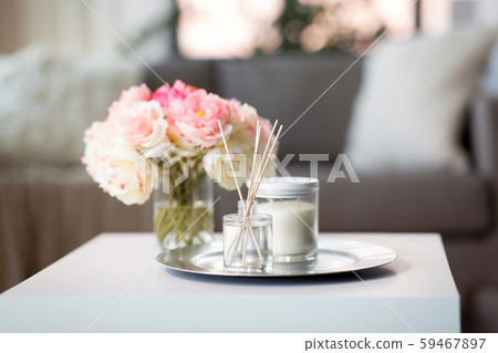 aroma reed diffuser, candle and flowers on table aroma reed diffuser, candle and flowers on table 59467897
