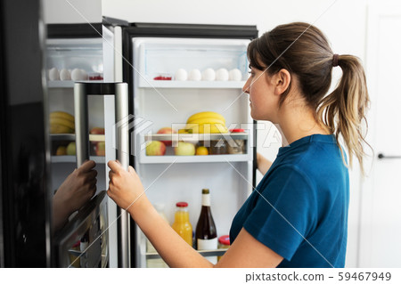 woman at open fridge at home kitchen woman at open fridge at home kitchen 59467949