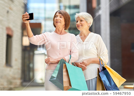old women with shopping bags taking selfie in city old women with shopping bags taking selfie in city 59467950