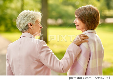 senior women or friends talking at summer park senior women or friends talking at summer park 59467951