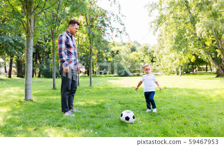 father with little son playing soccer at park father with little son playing soccer at park 59467953