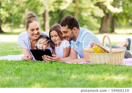 family with tablet pc on picnic in summer park family with tablet pc on picnic in summer park 59468219
