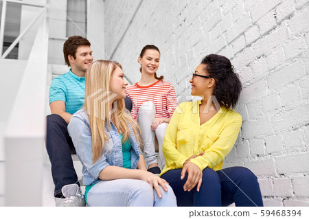 teenage friends or students hanging out on stairs teenage friends or students hanging out on stairs 59468394