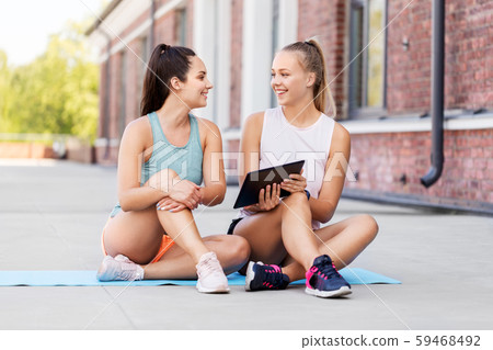 sporty women or friends with tablet pc on rooftop 59468492