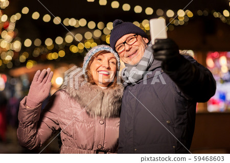 senior couple taking selfie at christmas market 59468603