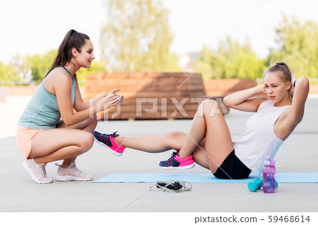 women training and doing bicycle crunches outdoors 59468614